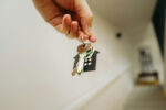 Landlord holding house keys at the doorway of a rental property