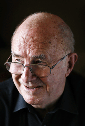 clive james glasses black background smiling