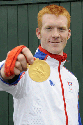 ed clancy olympic cyclist holding up gold medal